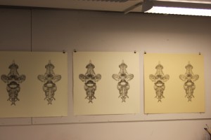 Various proofs of a print hanging in the Tamarind Institute. Different types of paper are also utilized here, and the artist and printer will choose the paper they think is best for the print.